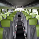 Wnętrze autokaru FlixBus, zielone siedzenia tworzą pusty korytarz. Idealne miejsce na podróż.