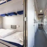 Wnętrze wagonów sypialnych PKP. Przytulne łóżka z pościelą i wygodne miejsca do odpoczynku.