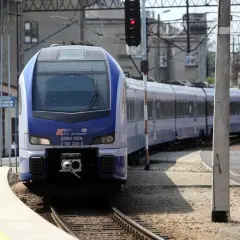 Niebiesko-biały pociąg PKP Intercity ED160-020b na torach, z sygnalizacją świetlną.