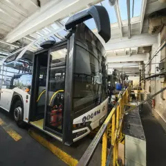Autobus miejski w zajezdni MZK. Wnętrze hali serwisowej z żółtymi barierkami i wyposażeniem technicznym.