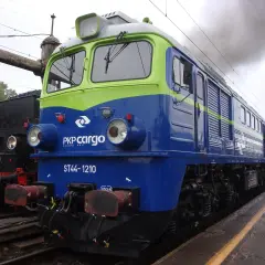 Lokomotywa ST44-1210 PKP Cargo, symbol Solidarności, dymi na tle parowozu.