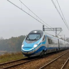 Pendolino pędzi po torach, łącząc Kraków z Warszawą. Pociąg PKP Intercity wjeżdża w mglisty krajobraz.