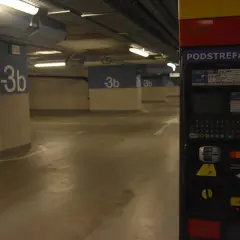 Podziemny parking na dworcu fabrycznym jest płatny. Widać parkingowy automat z klawiaturą i opcjami płatności.