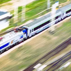 Pociąg Intercity pędzi po torach, oferując szybki sposób, jak dojechać z Krakowa do Dąbek nad morzem.
