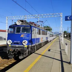 Niebiesko-szary pociąg PKP Intercity EP07-1022 stoi na peronie. Zastanawiasz się, ile jedzie pociąg z Poznania do Krakowa?