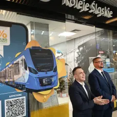 Promocja Kolei Śląskich z rabatem 10% w aplikacji. Na ekranie smartfona widok nowoczesnego pociągu.