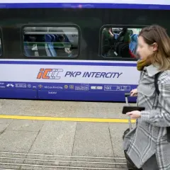 Kobieta z walizką na peronie PKP Intercity, przygotowuje się do podróży mimo podwyżek cen biletów.