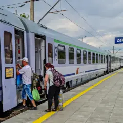 Ludzie wsiadają do pociągu PKP Intercity w Zakopanem. Czy u konduktora można płacić kartą? Tego nie widać, ale podróżni mają bagaże.