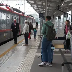 Ludzie na peronie czekają na pociąg. Zastanawiasz się, ile zarabia kierowca pociągu?