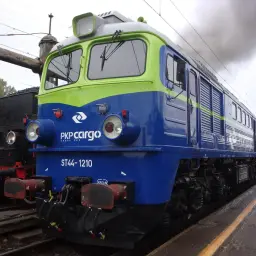 Lokomotywa ST44-1210 PKP Cargo, symbol Solidarności, dymi na tle parowozu.