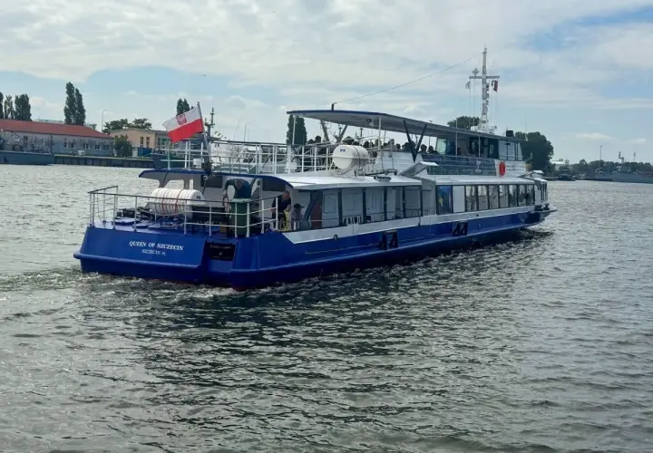 Nadmorski tramwaj wodny "Queen of Szczecin" płynie po wodzie, unosząc polską flagę.