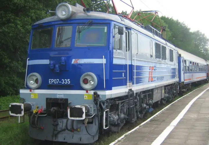 Niebieska lokomotywa EP07-335 PKP Intercity z pociągiem pasażerskim na stacji.