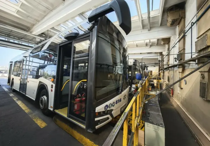 Autobus miejski w zajezdni MZK. Wnętrze hali serwisowej z żółtymi barierkami i wyposażeniem technicznym.