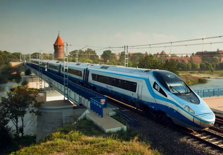 Nowoczesny pociąg Pendolino jedzie po moście nad rzeką. W tle widać zamek. Czy bilet bez wskazania miejsca jest tańszy?