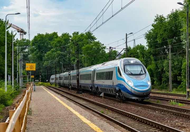 Srebrno-niebieski pociąg Pendolino mija peron. Ile pociągów Pendolino jest w Polsce? Ten jeden jest na torach.