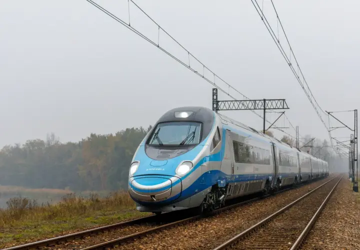 Pendolino pędzi po torach, łącząc Kraków z Warszawą. Pociąg PKP Intercity wjeżdża w mglisty krajobraz.