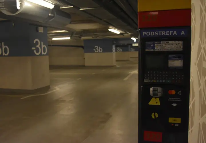 Podziemny parking na dworcu fabrycznym jest płatny. Widać parkingowy automat z klawiaturą i opcjami płatności.
