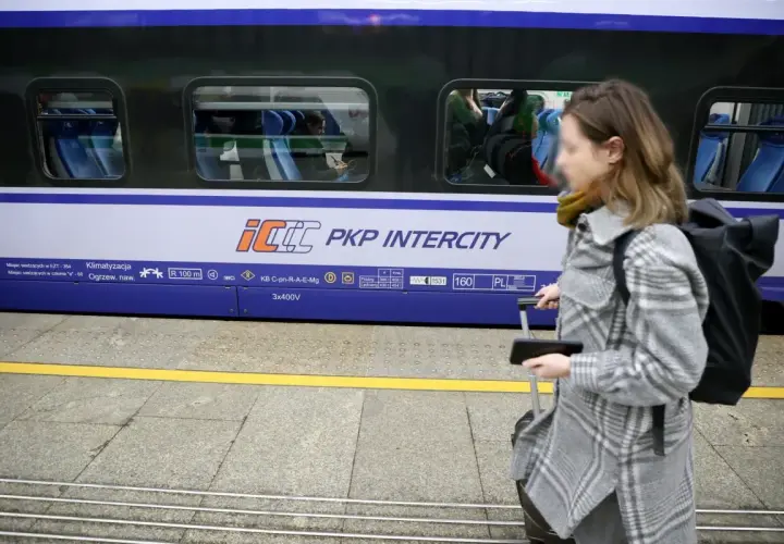 Kobieta z walizką na peronie PKP Intercity, przygotowuje się do podróży mimo podwyżek cen biletów.