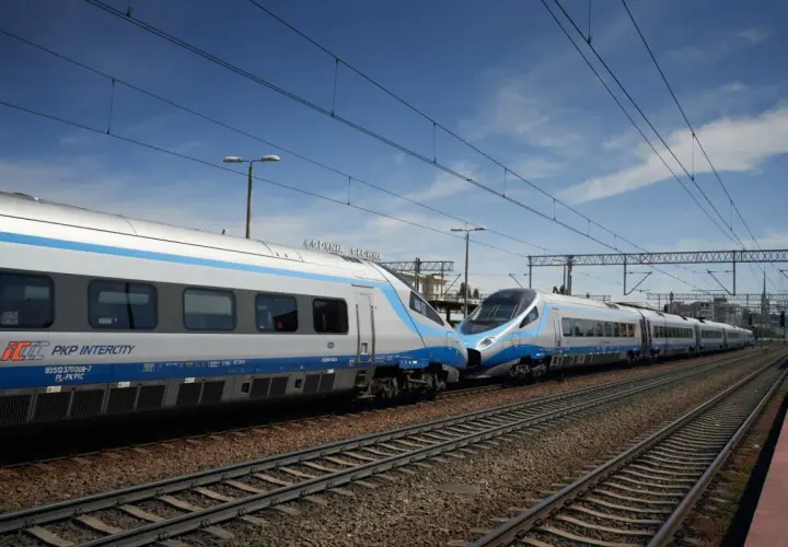 Dwa pociągi Pendolino PKP Intercity stoją obok siebie na torach.