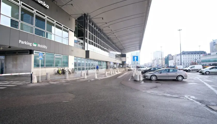 Parking przy Dworcu Centralnym w Warszawie, z widocznym budynkiem Biedronki i samochodami.