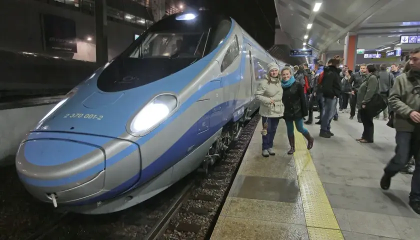 Dwie kobiety na peronie czekają na Pendolino z Gdańska do Krakowa. Pociąg jest nowoczesny i szybki.