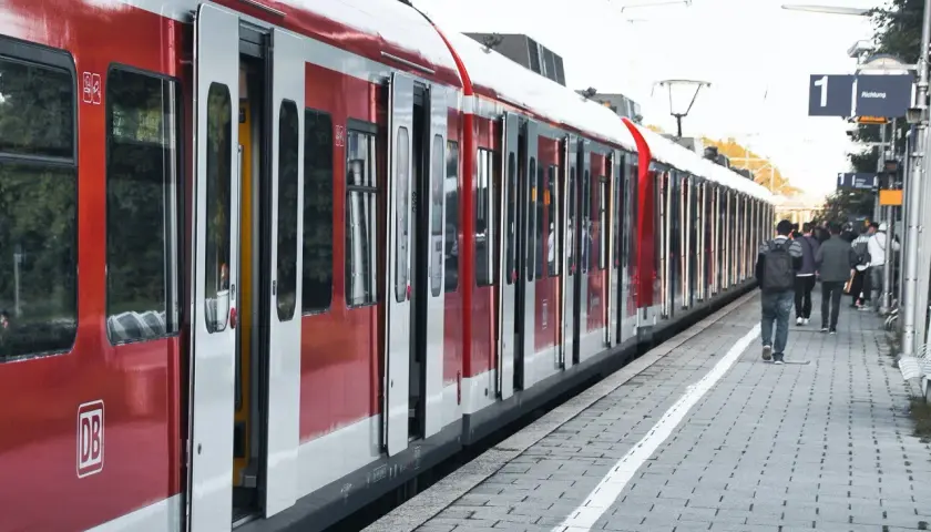 Czerwony pociąg na peronie, ludzie czekają na podróż. Dowiedz się, jak zmienić bilet PKP Intercity, by podróżować bez stresu.