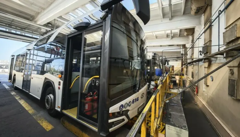 Autobus miejski w zajezdni MZK. Wnętrze hali serwisowej z żółtymi barierkami i wyposażeniem technicznym.