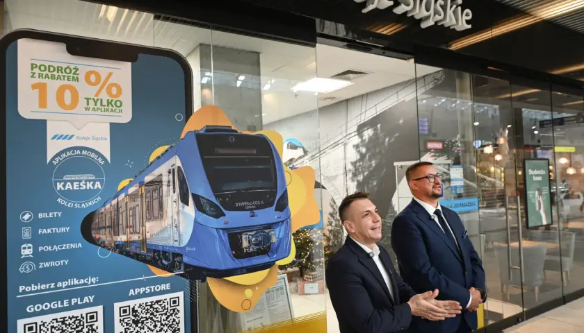 Promocja Kolei Śląskich z rabatem 10% w aplikacji. Na ekranie smartfona widok nowoczesnego pociągu.