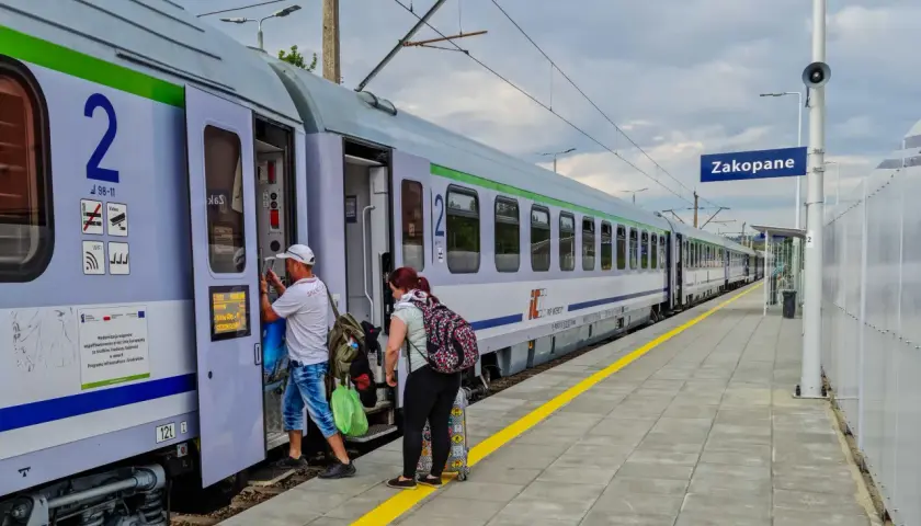 Ludzie wsiadają do pociągu PKP Intercity w Zakopanem. Czy u konduktora można płacić kartą? Tego nie widać, ale podróżni mają bagaże.