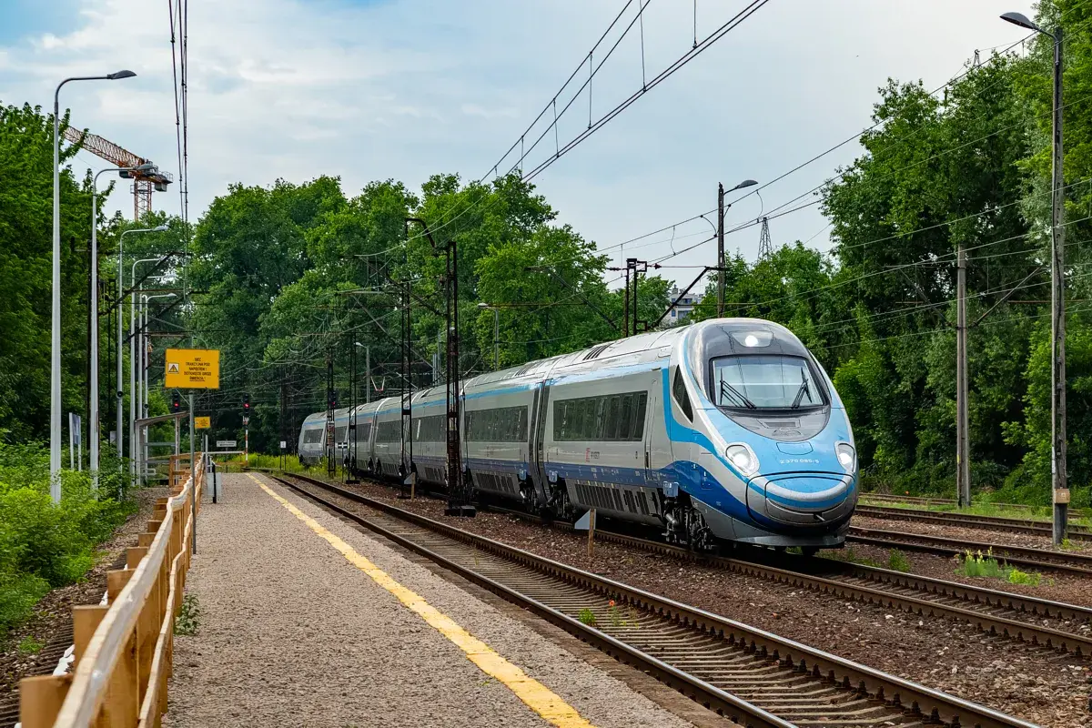 Srebrno-niebieski pociąg Pendolino mija peron. Ile pociągów Pendolino jest w Polsce? Ten jeden jest na torach.