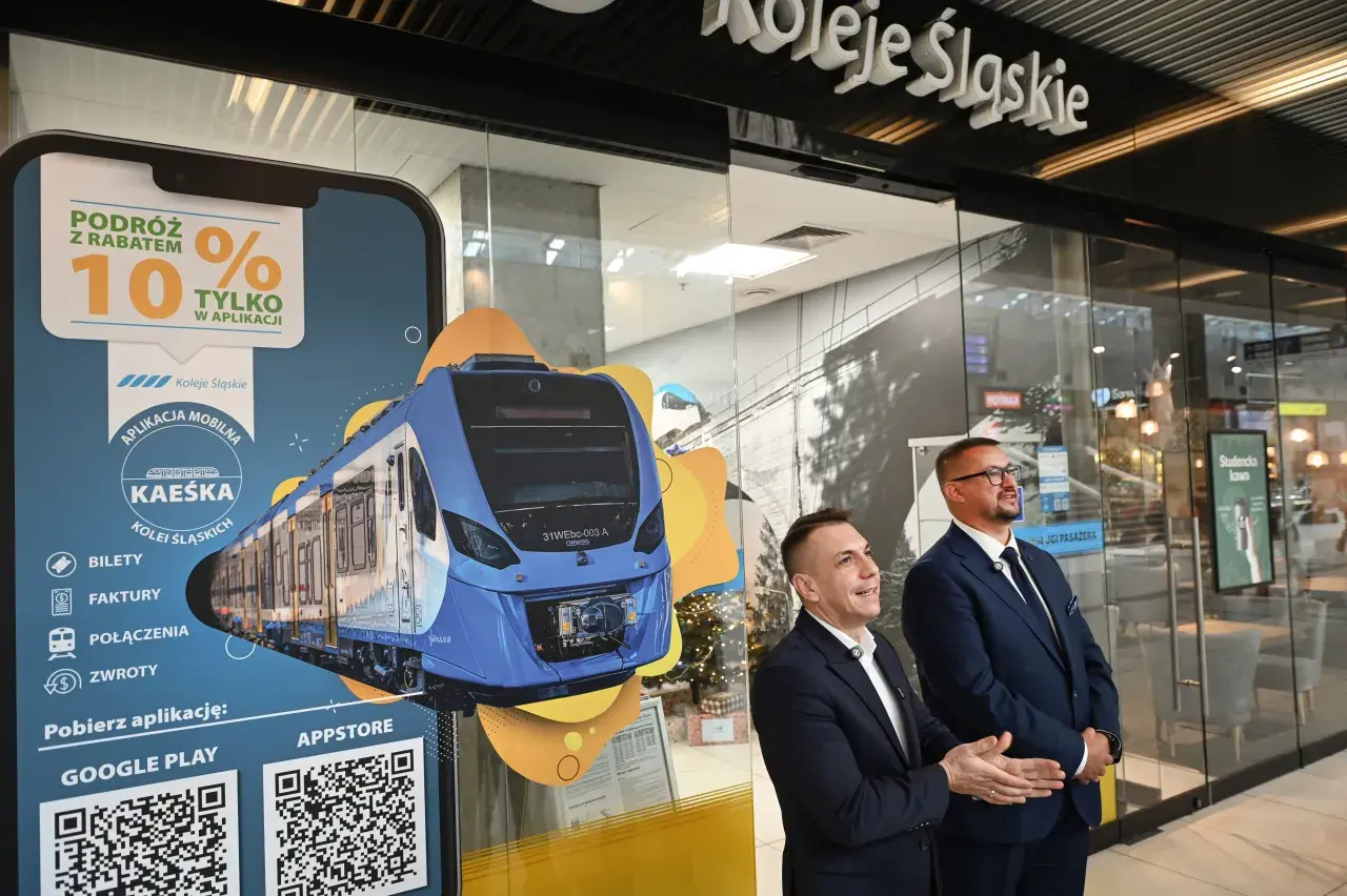 Promocja Kolei Śląskich z rabatem 10% w aplikacji. Na ekranie smartfona widok nowoczesnego pociągu.