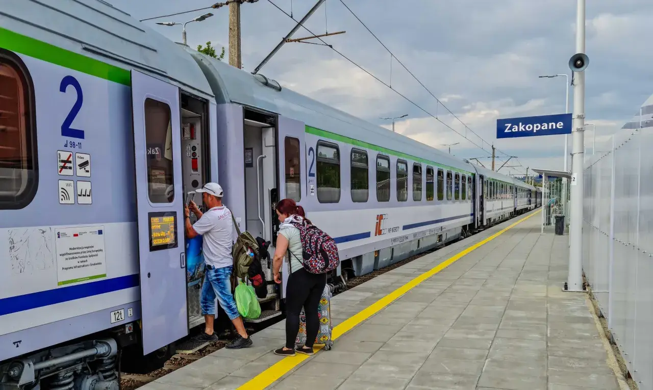 Ludzie wsiadają do pociągu PKP Intercity w Zakopanem. Czy u konduktora można płacić kartą? Tego nie widać, ale podróżni mają bagaże.