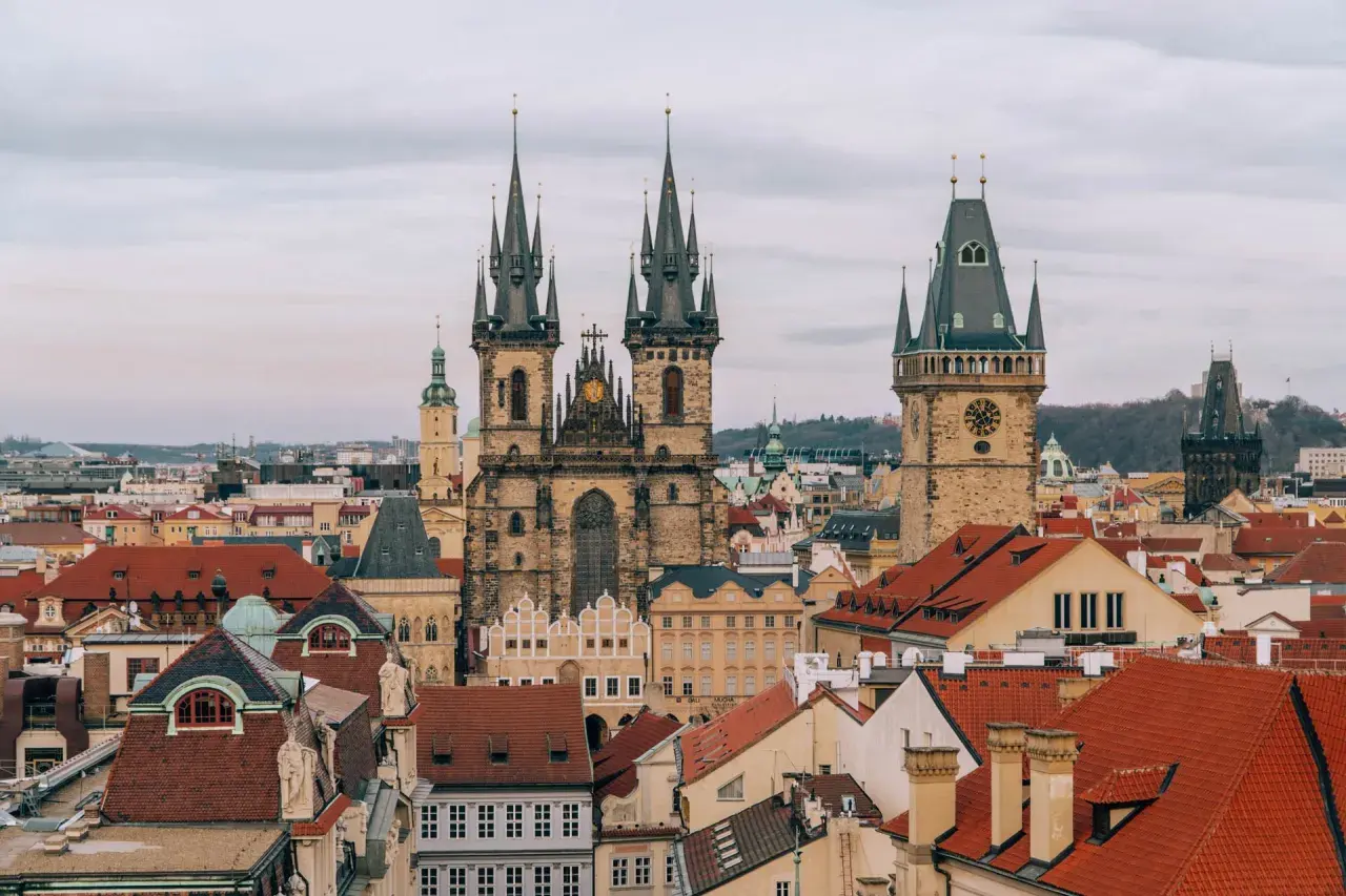 Widok na praską Starówkę z wieżami kościoła Marii Panny przed Tynem i Ratuszem Staromiejskim. W oddali widać nowoczesne budynki, a gdzieś tam pewnie jedzie pociąg w Czechach.