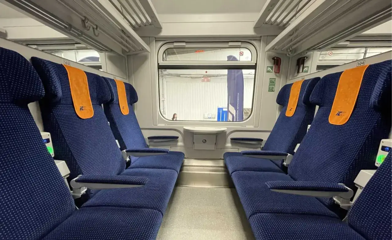 Wnętrze wagonów Porta Moravia. Komfortowe, granatowe fotele z pomarańczowymi zagłówkami czekają na pasażerów.