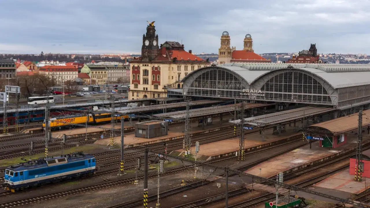 Widok na dworzec kolejowy w Pradze, gdzie pociąg w Czechach czeka na pasażerów. W tle zabytkowa architektura miasta.