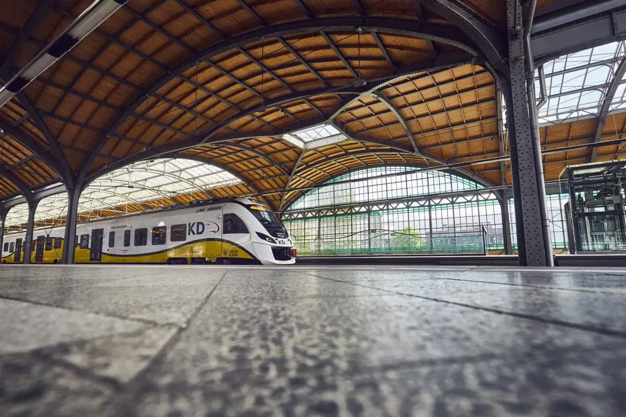 Nowoczesny pociąg KD na zabytkowym dworcu Wrocław Nadodrze PKP. Drewniany dach i stalowe konstrukcje tworzą niepowtarzalny klimat.