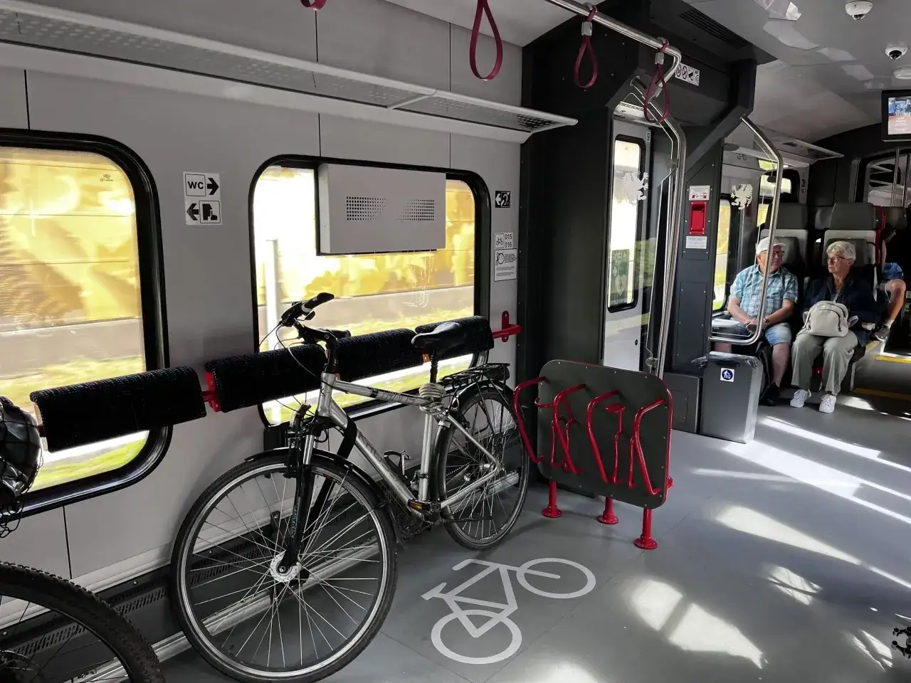 Wnętrze pociągu Koleje Dolnośląskie z rowerami i miejscami dla pasażerów.