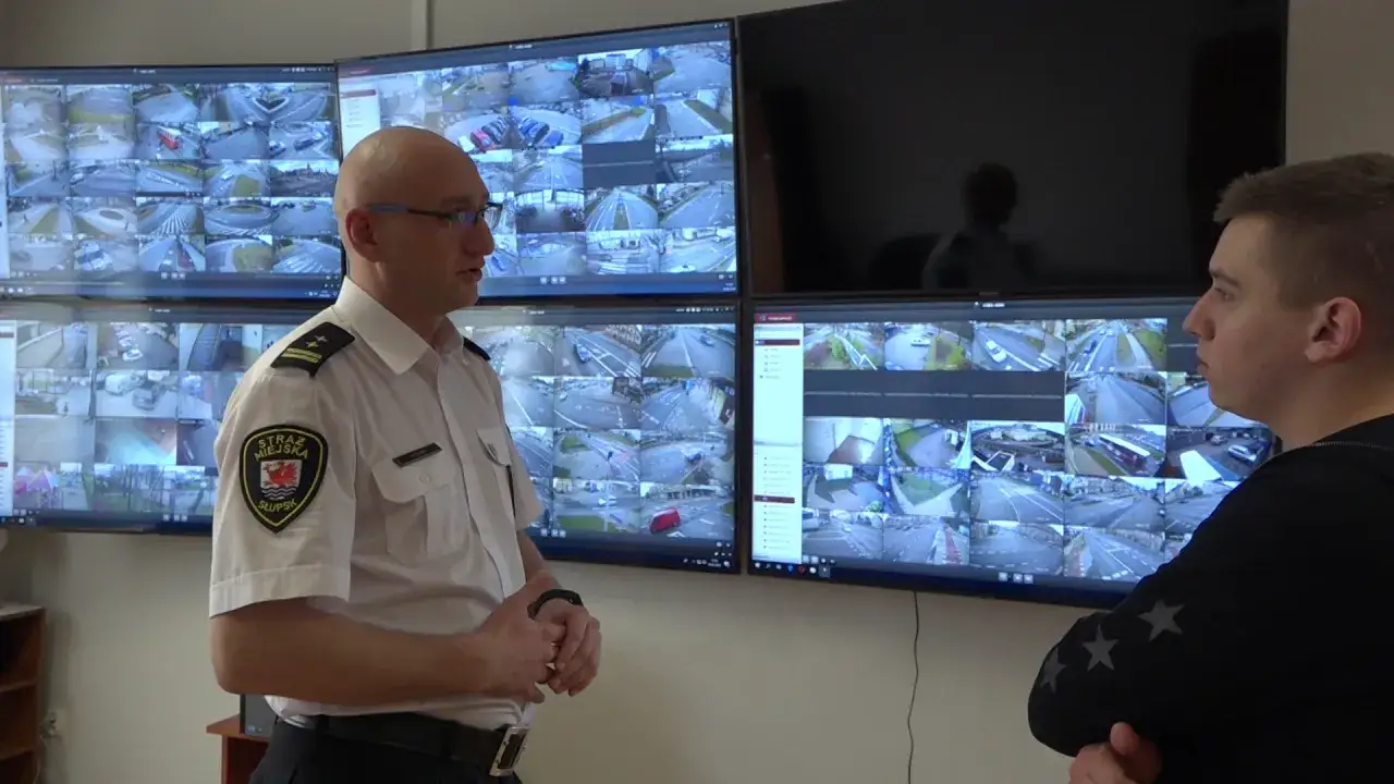 Strażnik miejski w Słupsku omawia obraz z kamer monitoringu na dworcu.