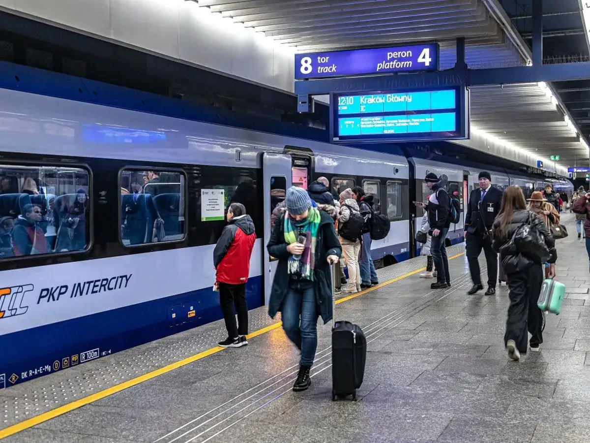 Ludzie z bagażami czekają na pociąg PKP Intercity. Zastanawiam się, czy kupię bilet u konduktora.