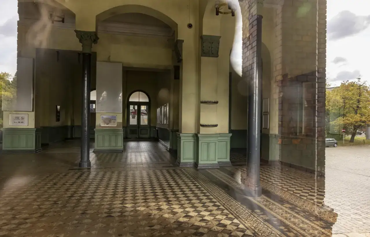 Wnętrze dworca Wrocław Nadodrze PKP z charakterystyczną posadzką i zielonymi elementami.