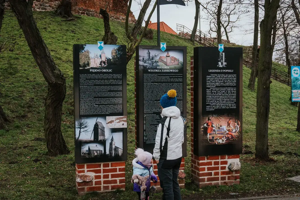 Dzieci poznają historię i legendy na drodze do Goplany, czytając tablice informacyjne przy zamku.